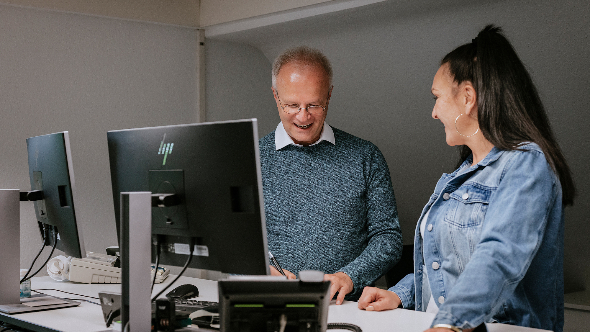 Ein Mann und eine Frau stehen an einem Schreibtisch