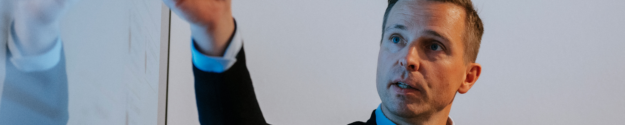 Ein Mann zeigt auf einen großen Monitor