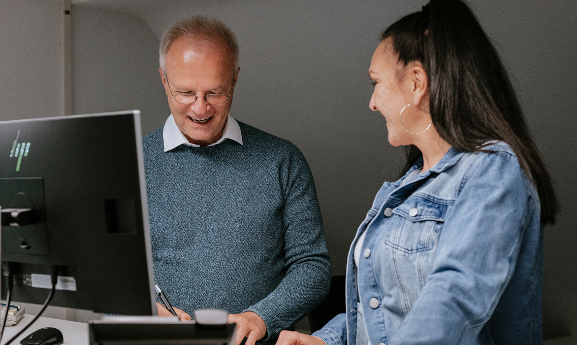 Ein Mann und eine Frau stehen an einem Schreibtisch
