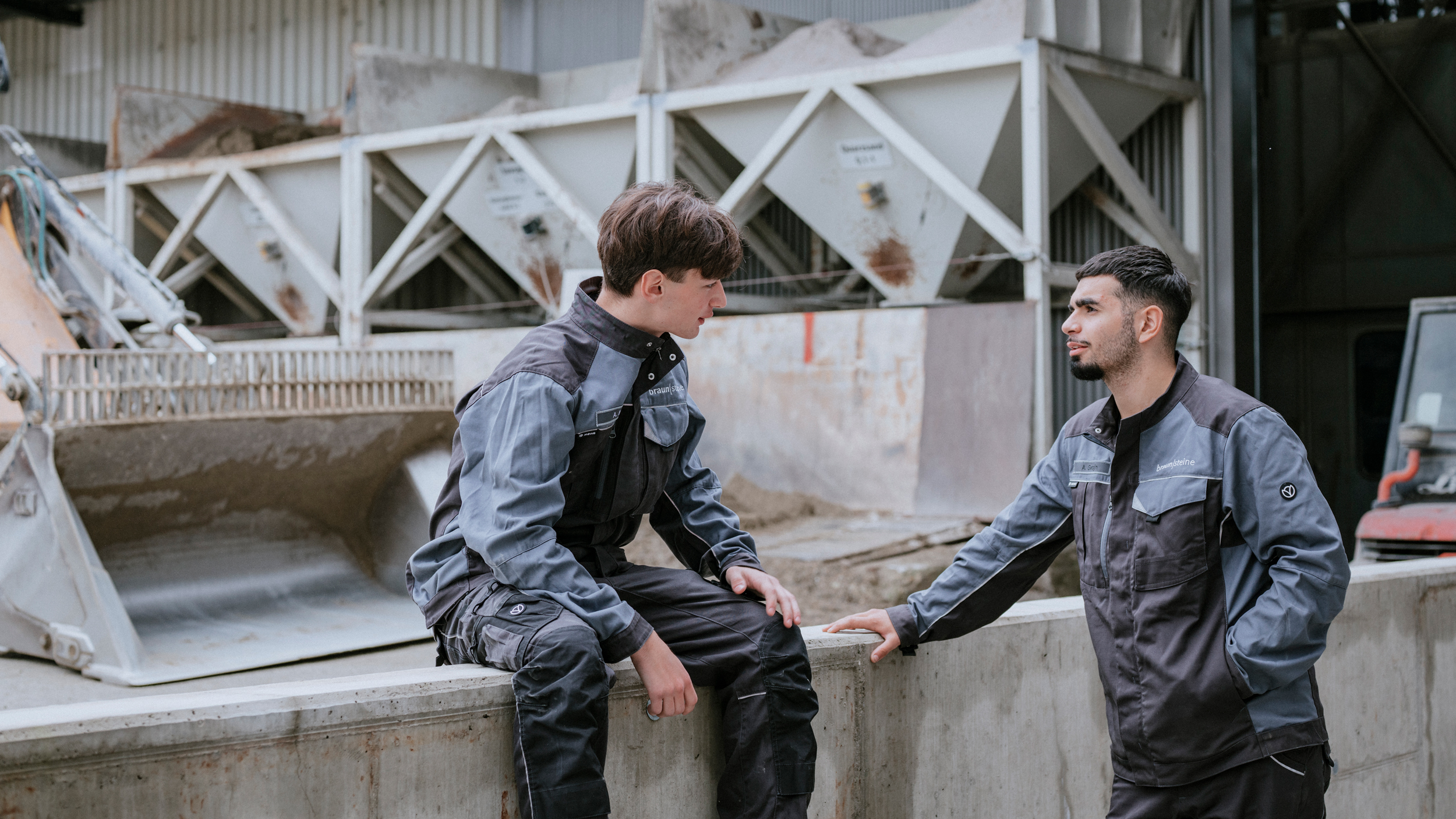 Zwei Azubis aus der Produktion unterhalten sich miteinander