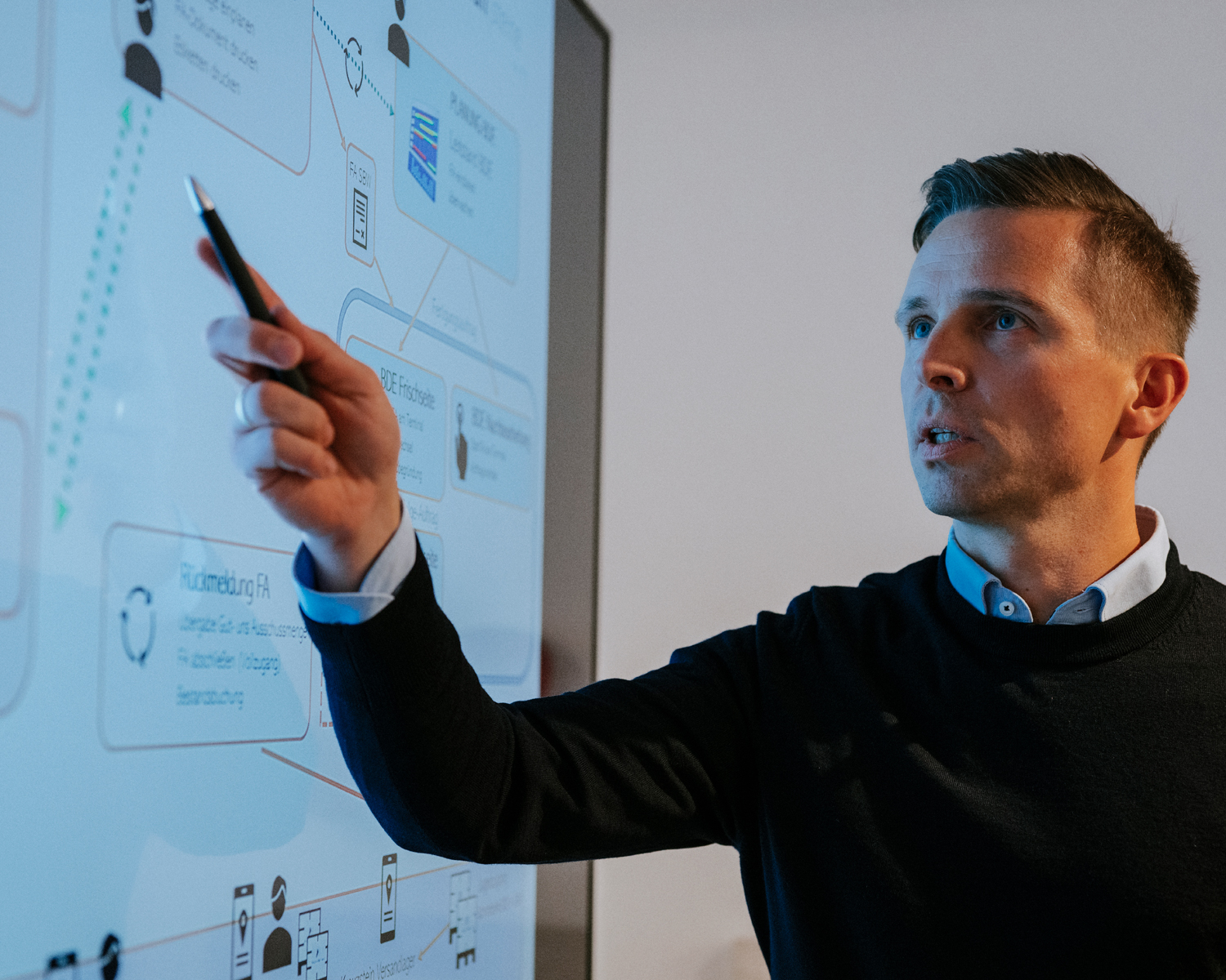 Ein Mann steht an einem großen Monitor